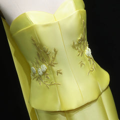 Yellow dress with floral embroidery on a black background