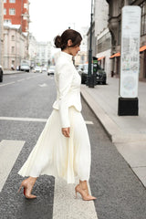 Woman in a white outfit walking on a city street