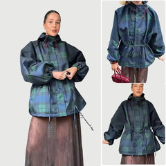 Woman wearing a plaid raincoat with a white background