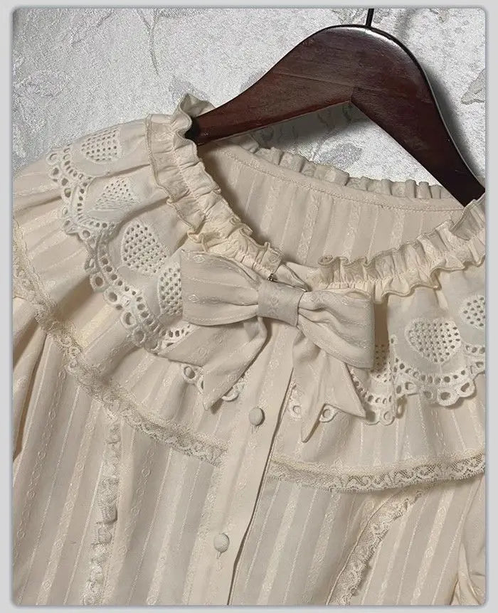 Close-up of the lace collar and bow detail on a cream blouse