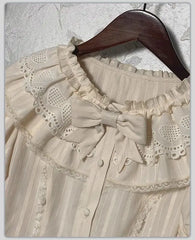 Close-up of the lace collar and bow detail on a cream blouse