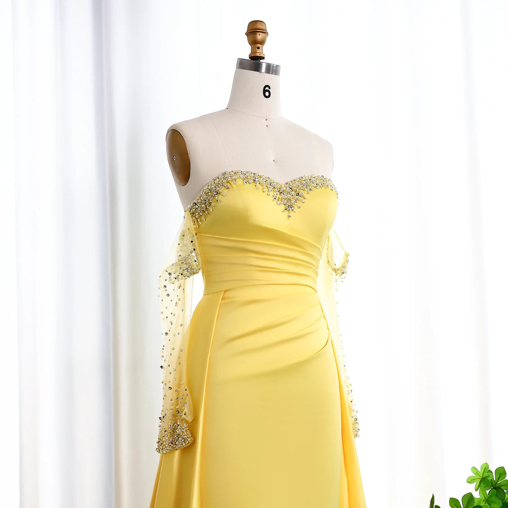 Yellow evening gown with lace sleeves on a mannequin against a white background