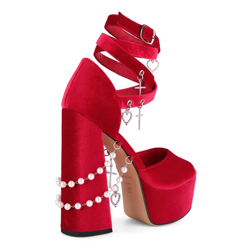 Red high-heeled platform shoes with decorative straps and pearls on a white background