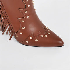 Close-up of the pointed toe on brown faux leather ankle boots with stud embellishments.