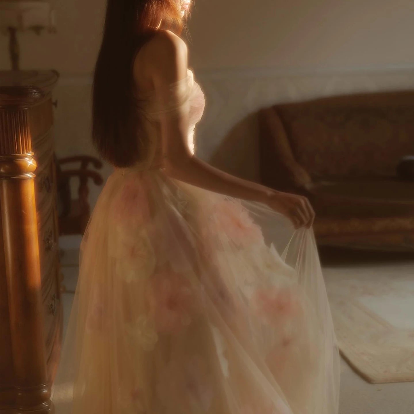Woman in a floral dress standing in a softly lit room.