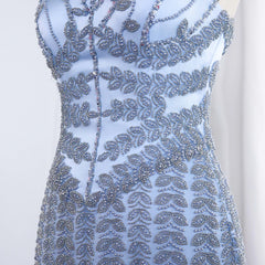 Blue beaded dress with intricate patterns on a white background