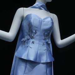 Mannequin wearing a light blue dress with floral embroidery on a black background