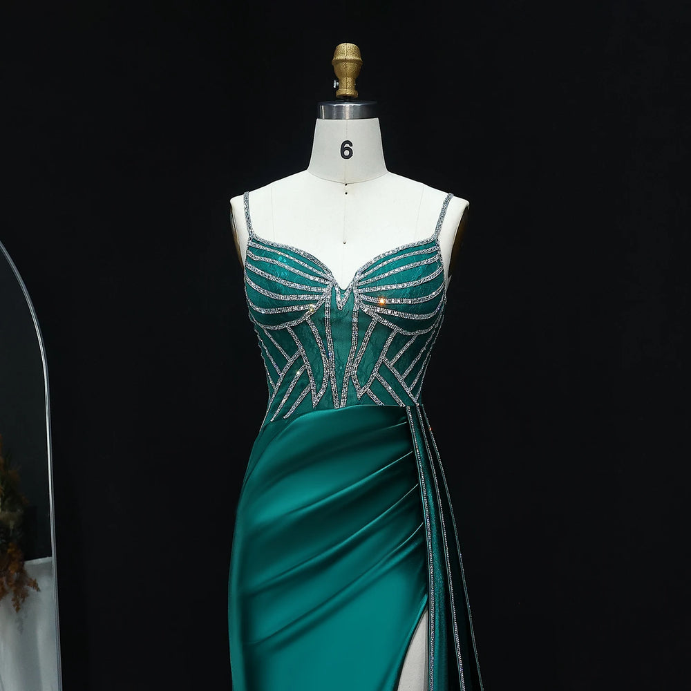 Teal evening gown with silver embellishments on a mannequin against a black background