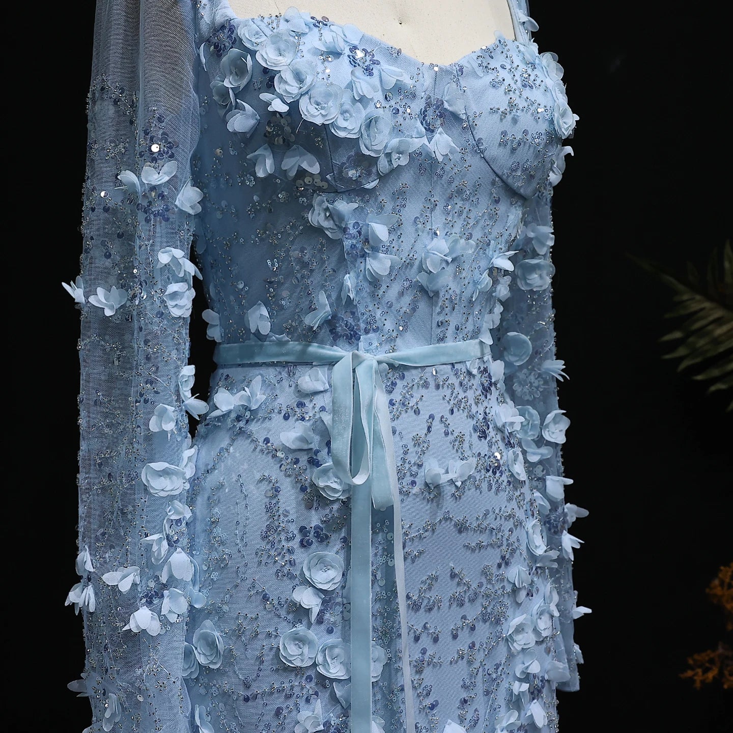 Blue lace dress on a mannequin against a dark background