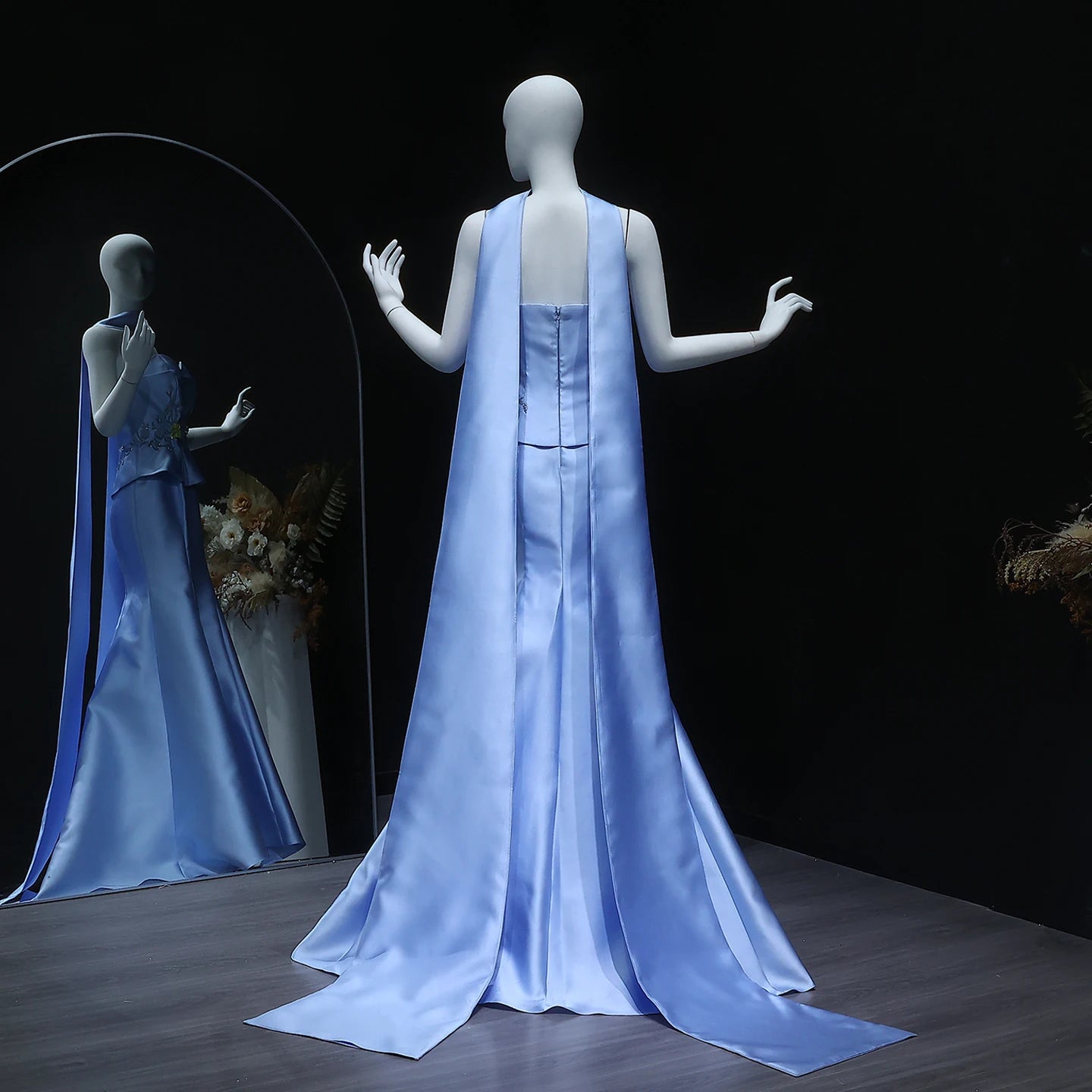 Mannequin wearing a light blue satin gown with a dark background