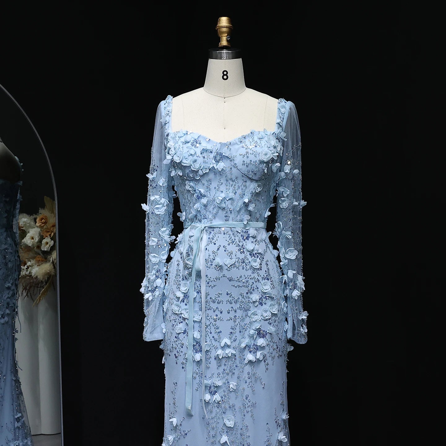 Light blue floral dress on a mannequin against a black background