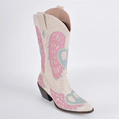 White cowboy boot with pink and blue heart and wing design on a white background