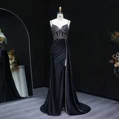 Black evening gown on a mannequin against a dark background