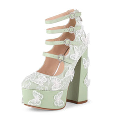 Light green high-heeled shoe with white lace and butterfly details on a white background