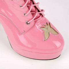 Detail of the toe area on pink patent leather lace-up boots with butterfly cutout