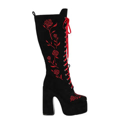 Black knee-high boot with red floral embroidery on a white background