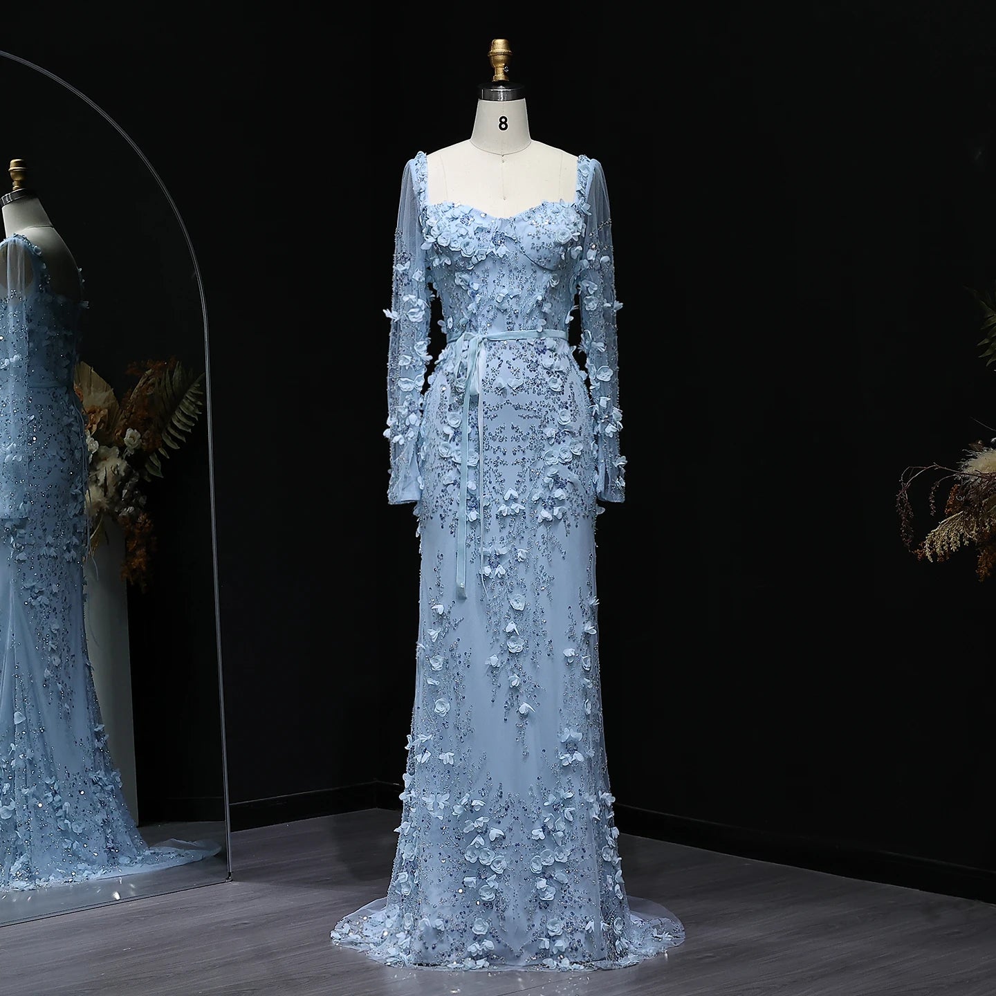 Light blue evening gown on a mannequin against a dark background