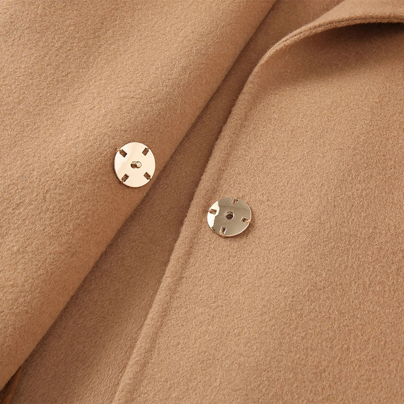Close-up of a brown fabric with two gold buttons.