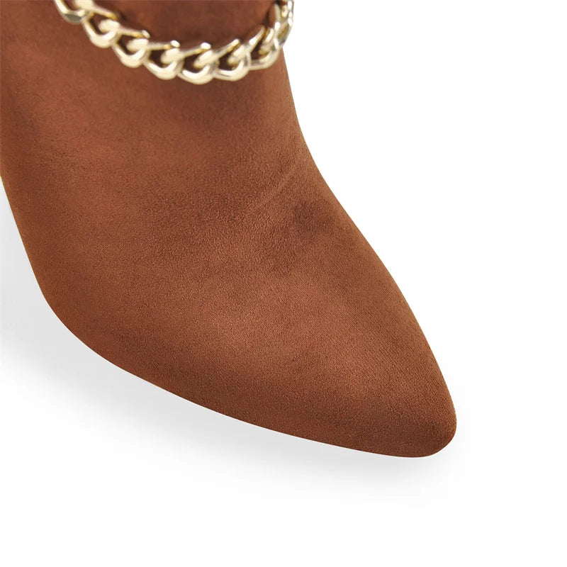 Close-up of the pointed toe and gold chain detail on a brown knee-high boot