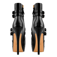Rear view of black faux leather platform stiletto ankle boots showing the stiletto heel and sole.