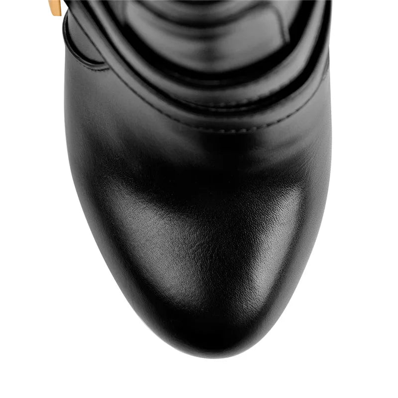 Close-up view of the pointed toe on black faux leather platform stiletto ankle boots.