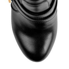 Close-up view of the pointed toe on black faux leather platform stiletto ankle boots.