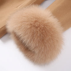 Close-up of a brown fur pom-pom on a beige fabric background