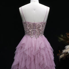 Pink evening gown with intricate beading on a mannequin against a dark background