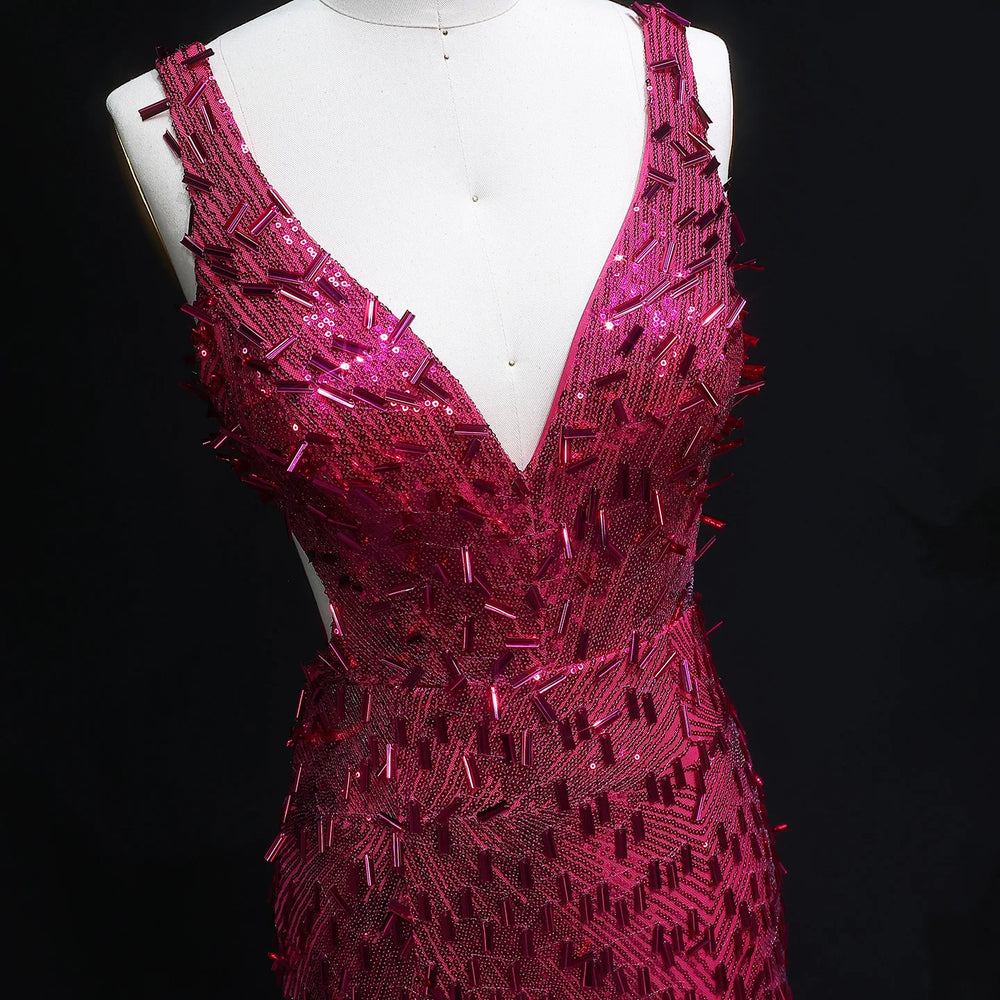 Pink beaded evening gown on a mannequin against a black background