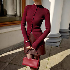 Person wearing a INS hot knit top red for high street and elegant layering and skirt holding a matching handbag outdoors.