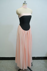 Mannequin wearing a black bodice with a pink skirt against a plain background