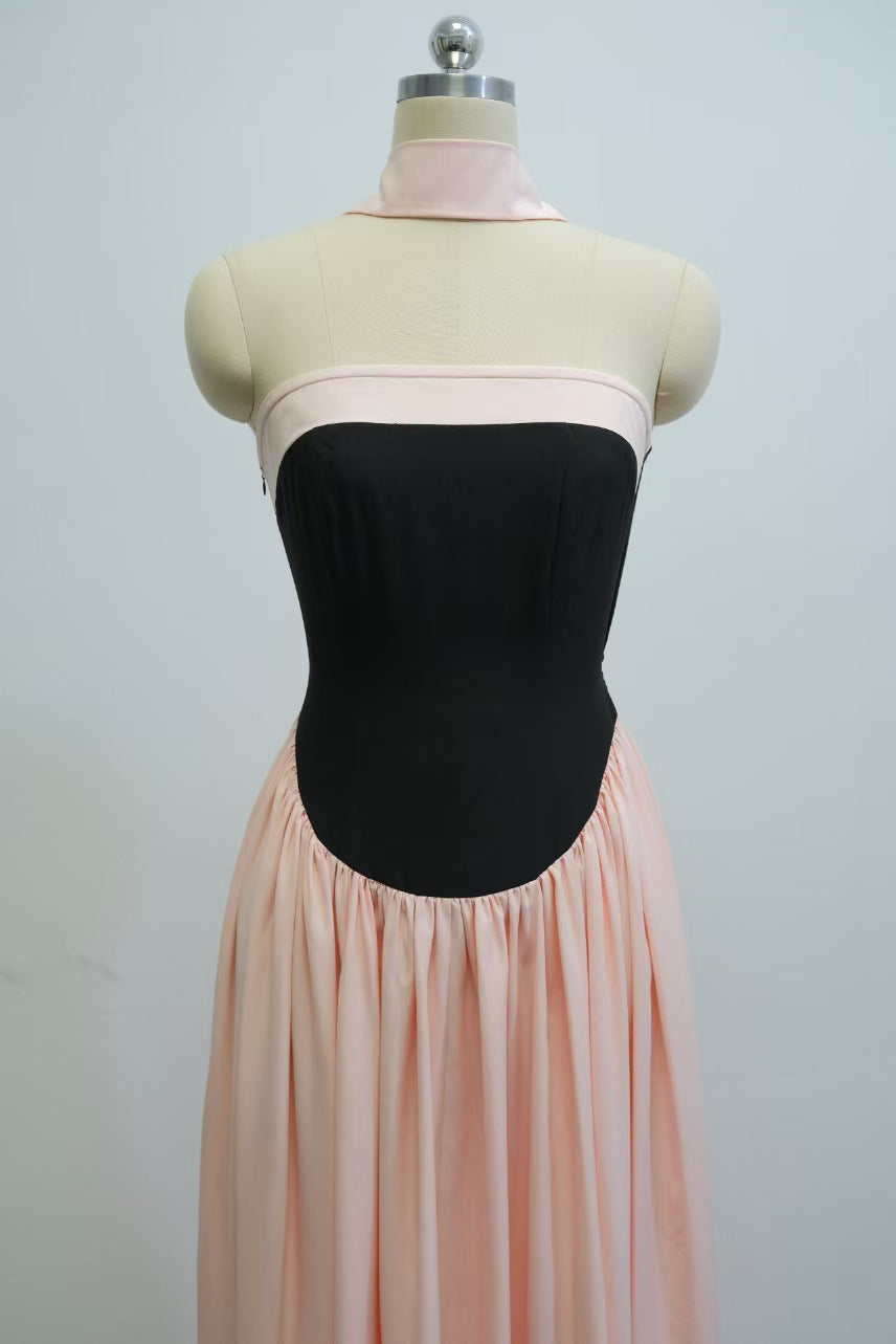 Mannequin wearing a black strapless top and pink pleated skirt against a plain background