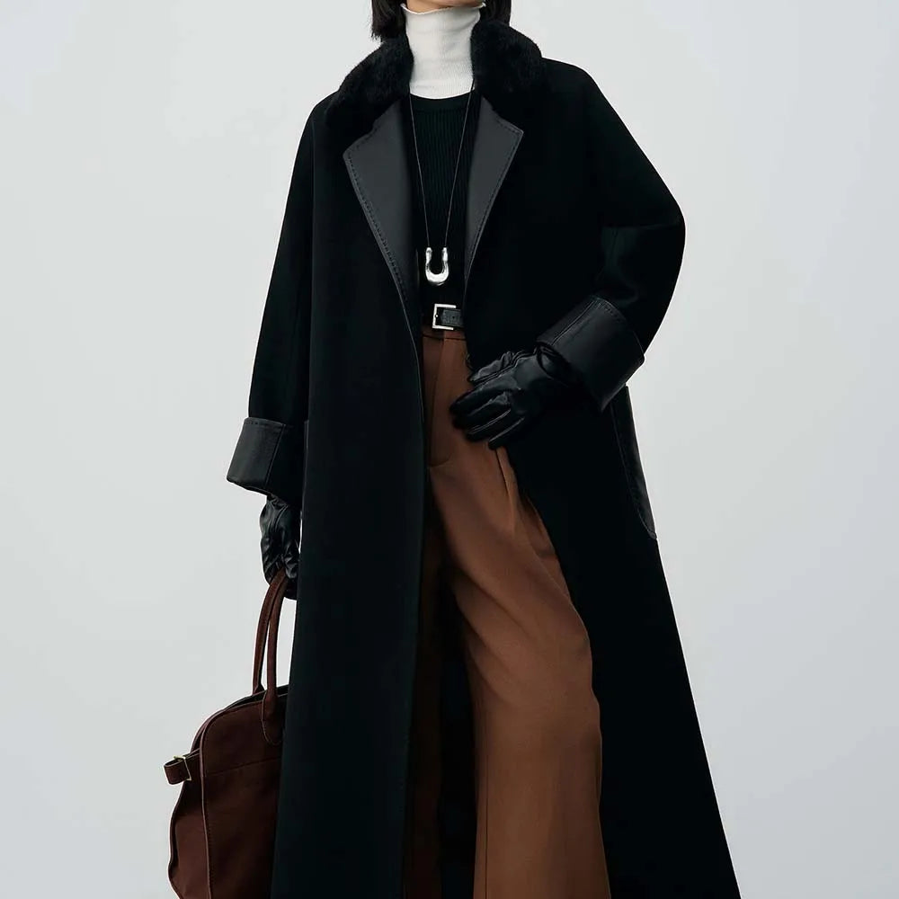 Person wearing a long black coat, brown pants, and holding a brown bag on a white background