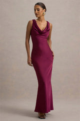 Woman wearing a burgundy evening gown against a neutral background
