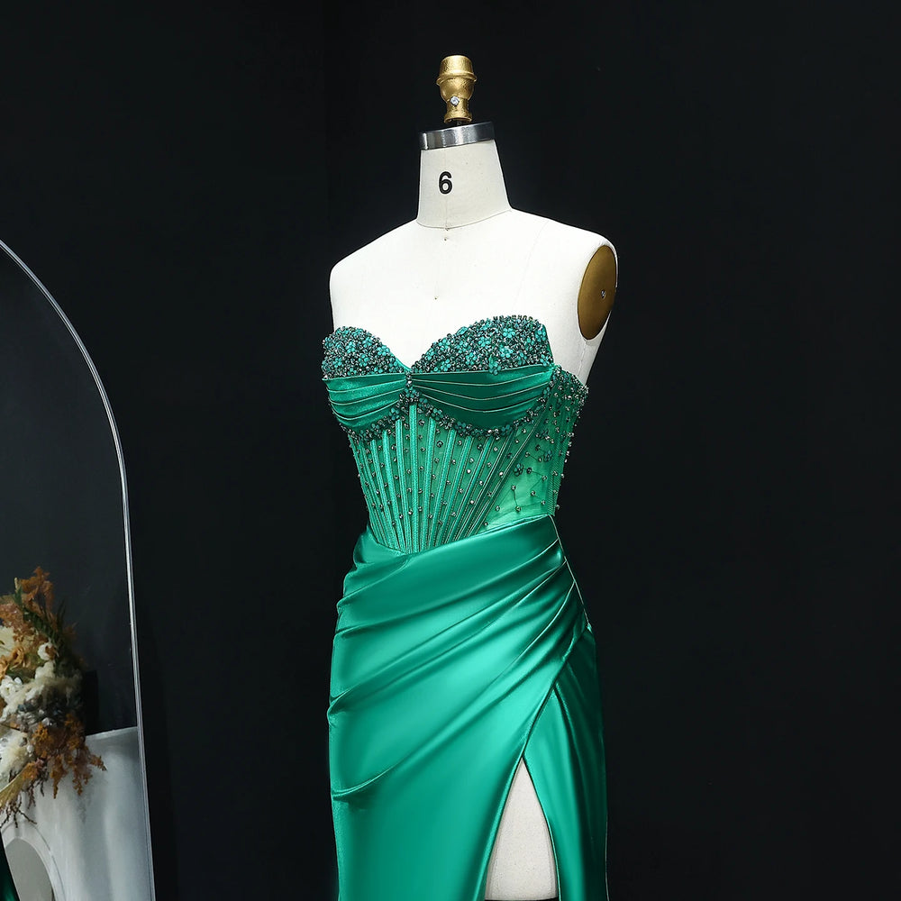 Green evening gown on a mannequin against a black background