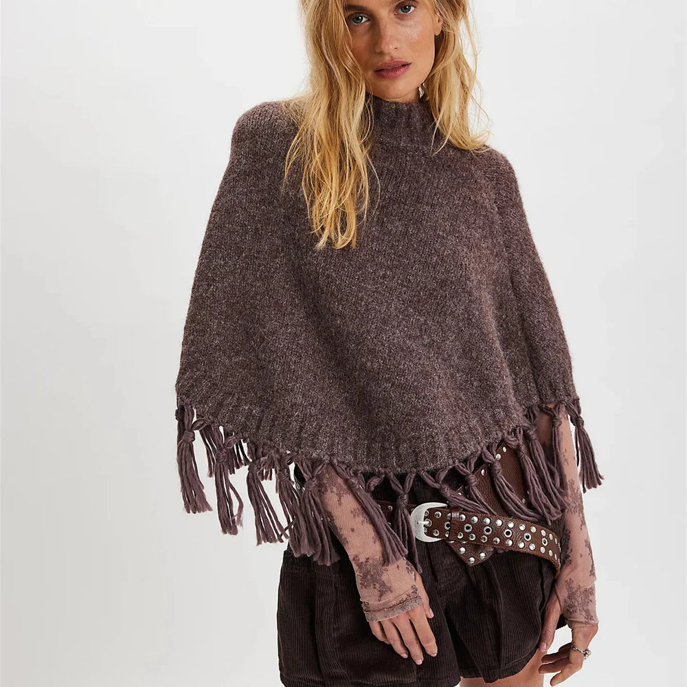 Woman wearing a brown poncho with tassels on a white background