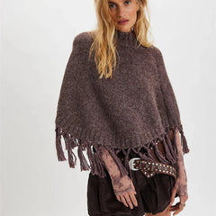Woman wearing a brown poncho with tassels on a white background