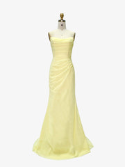 Yellow evening gown on a mannequin against a white background