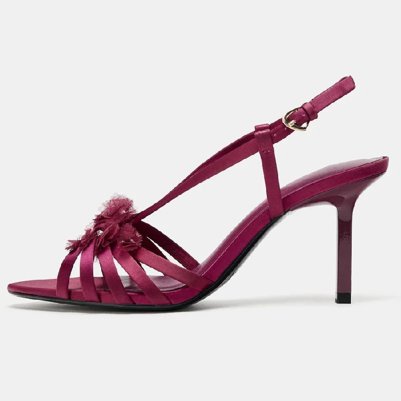 Side view of red satin heeled sandals with floral embellishments
