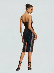 Woman wearing a black sequin dress on a light gray background