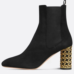 Side view of black suede ankle boot with gold heel detail