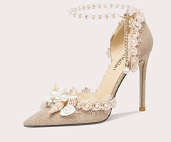 High-heeled shoe with floral and pearl details on a light gray background