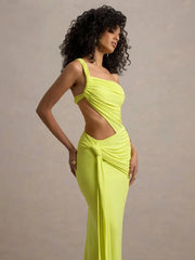 Woman wearing a bright yellow dress with cut-out design against a neutral background