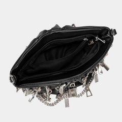 Black handbag with silver chains and padlocks on a light gray background