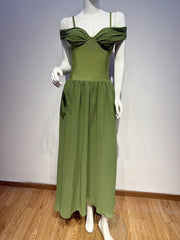 Green dress on a mannequin against a plain background