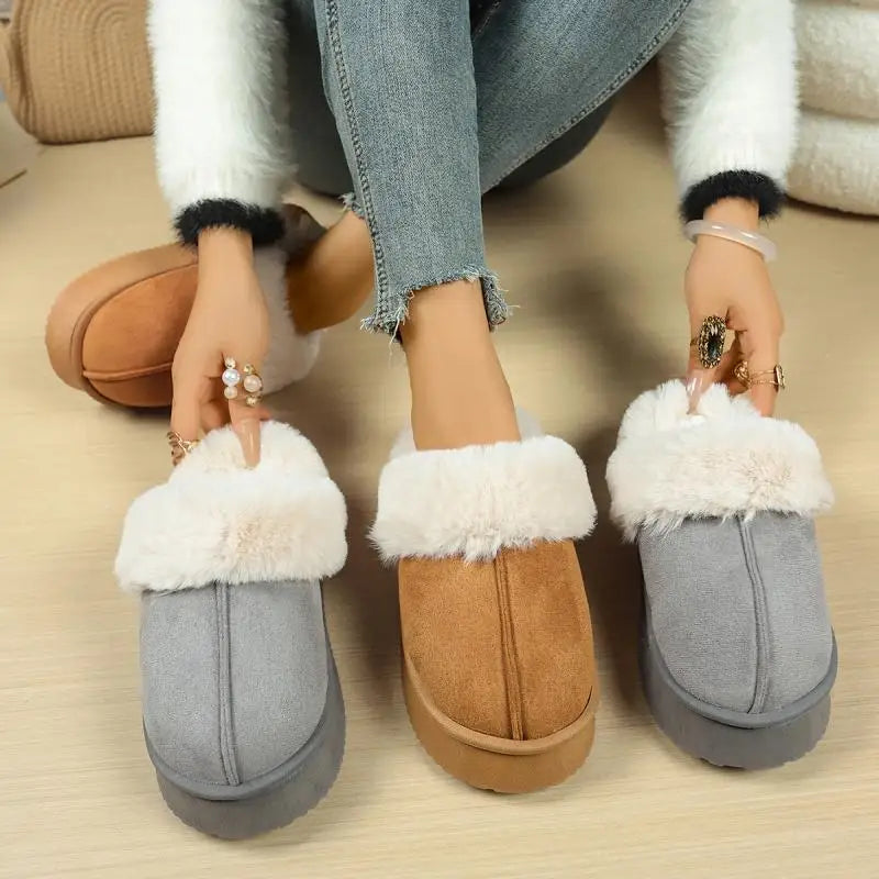 Two pairs of slippers, one brown and one gray, with white fur trim, on a wooden floor.