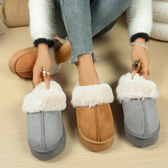 Two pairs of slippers, one brown and one gray, with white fur trim, on a wooden floor.