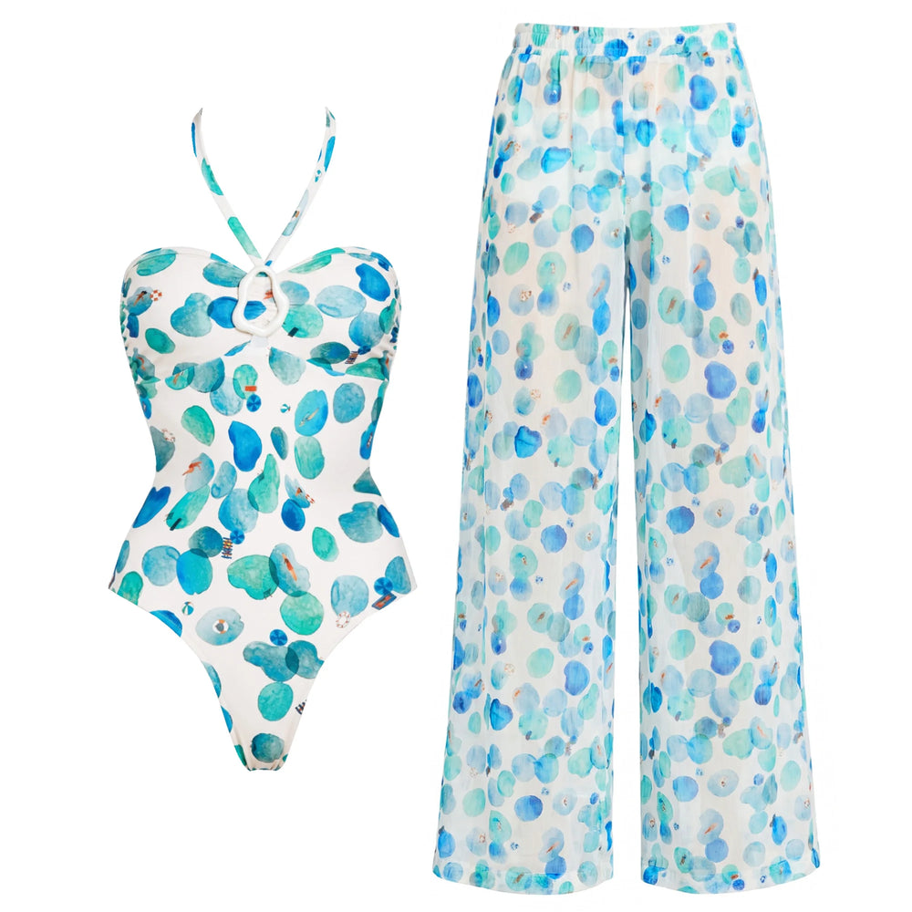 White one-piece swimsuit with abstract blue and green dots and matching wide-leg pants.