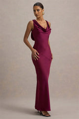 Woman wearing a burgundy evening gown against a neutral background