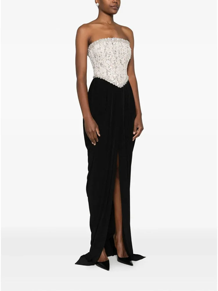 Woman wearing a strapless gown with a white top and black skirt on a white background